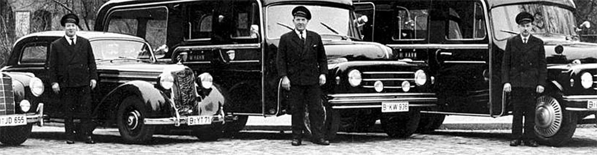 Schwarz/Weiß Bild von alten Bestatterwagen.