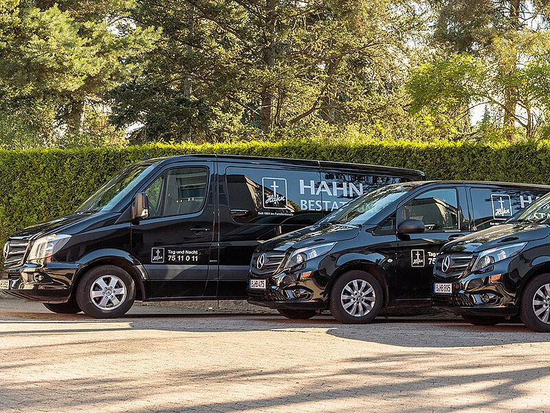 Vier schwarze Leichentransporter von Hahn Bestattungen.