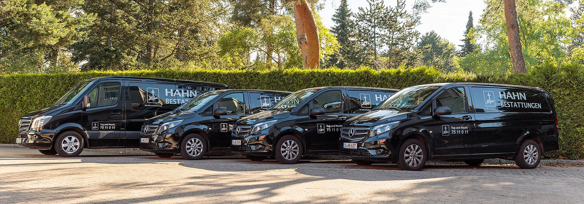 Vier schwarze Leichentransporter von Hahn Bestattungen.