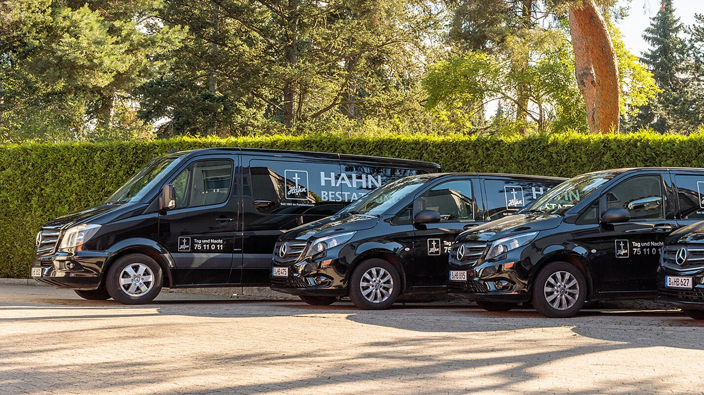 Vier schwarze Leichentransporter von Hahn Bestattungen.