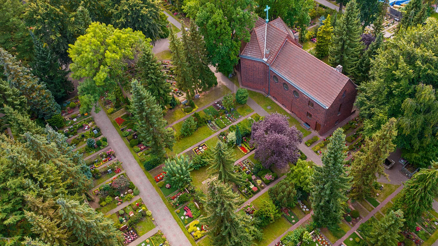 Luftaufnahme des evangelischen Friedhofs in Berlin-Marienfelde mit Kapelle.