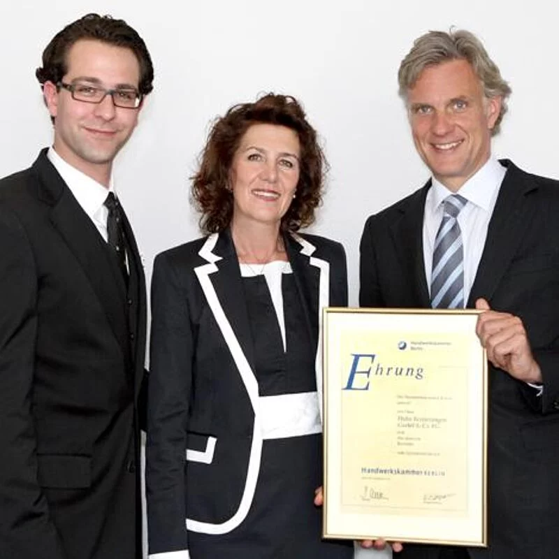 Stefan Schwarz, Präsident der Handwerkskammer, überreicht die Ehrenurkunde an Editha Hahn-Fink und Robert Hahn