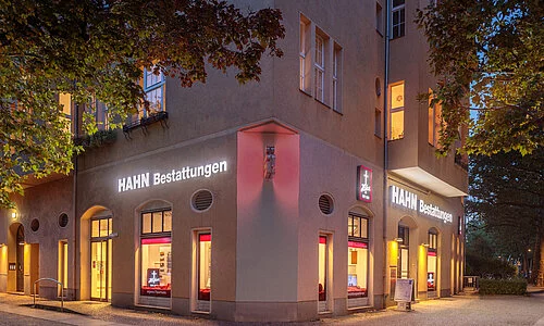 Beleuchtete Außenansicht der Hahn Bestattungen Filiale in der Assmanshausenstraße.